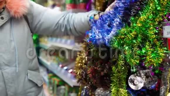 女孩在商场里选择圣诞假日装饰品视频的预览图