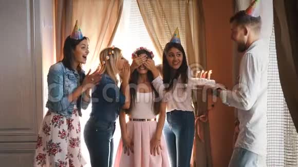 生日快乐的女孩和朋友许愿吹灭蛋糕上的蜡烛视频的预览图