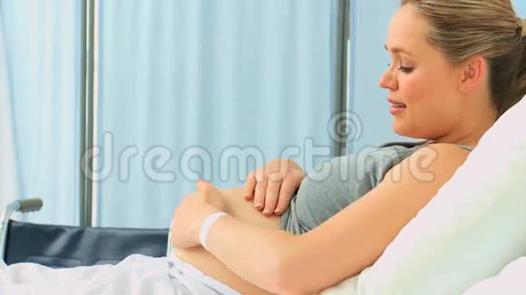 孕妇抚摸她的腹部视频的预览图