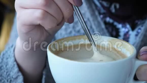 一个年轻女子在咖啡馆里喝着卡布奇诺视频的预览图