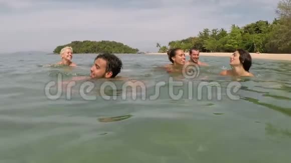 一群人在海水中游泳一群年轻朋友在海滩上一起拍摄镜头视频的预览图