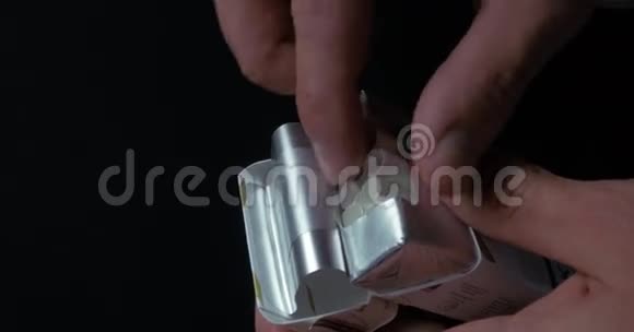 男人手从盒子里掏出一支烟把香烟从包装特写特写一个男人从一个视频的预览图