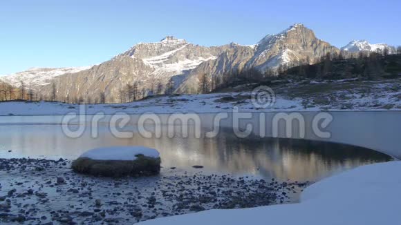 冬季河流流向意大利阿尔卑斯山冻结的山湖视频的预览图