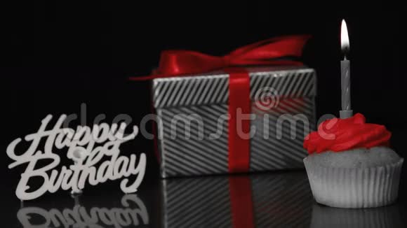小蛋糕上的蜡烛放在礼物和生日快乐标志旁边视频的预览图