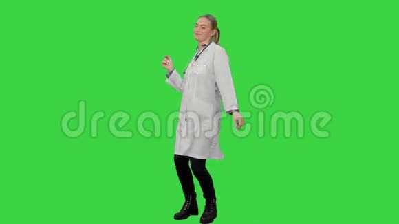 微笑的年轻女子穿着实验室外套在绿色屏幕上做有趣的舞蹈Chroma键视频的预览图