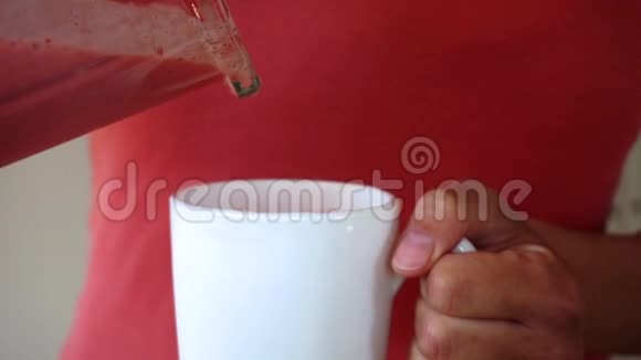 年轻女孩在白色杯子里倒草莓香味高清视频视频的预览图