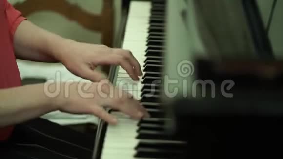 女孩钢琴键盘上的手女孩弹钢琴合上钢琴手放在钢琴的白键上视频的预览图