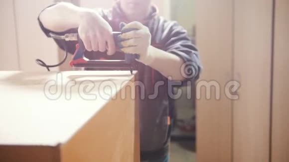 木匠在工厂里用一个电动工业订书机修理家具的细节视频的预览图