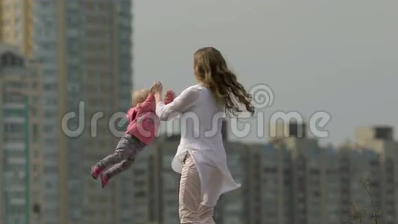 妈妈和她的小女儿一起旋转旋转旋转绕圈视频的预览图