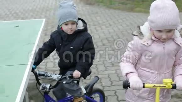 慢动作孩子们骑迷你滑板车和自行车视频的预览图