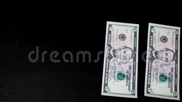 五美元钞票在黑桌上移动4K视频视频的预览图