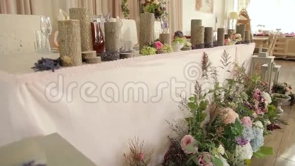 新娘和新郎的婚礼桌上有木制烛台上的蜡烛视频的预览图