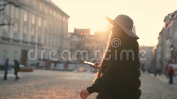 年轻女子戴着灰色帽子蓝眼睛漂亮长发在城市里通过智能手机进行交流视频的预览图