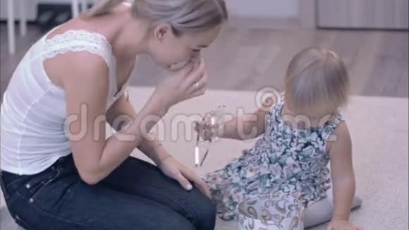 快乐的年轻妈妈和她的小女儿在地毯上探索珠宝盒视频的预览图