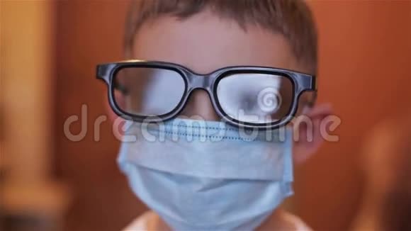 医院里一个戴眼镜和面具的男孩的特写视频的预览图