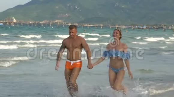 可爱的快乐夫妇在海滩散步视频的预览图