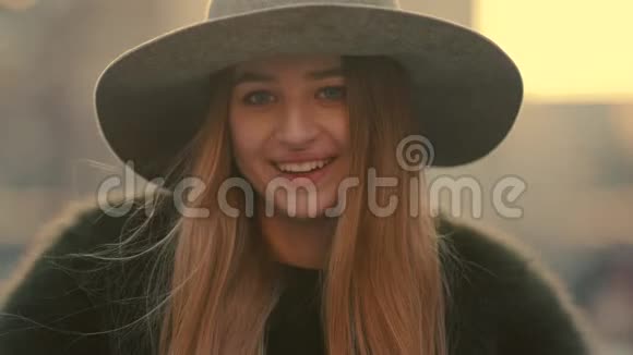 一个身穿灰色帽子的迷人的年轻姑娘看上去很对微笑着走向镜头视频的预览图