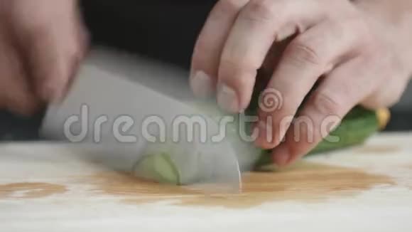 青年主厨用刀切薄片绿色有机黄瓜视频的预览图