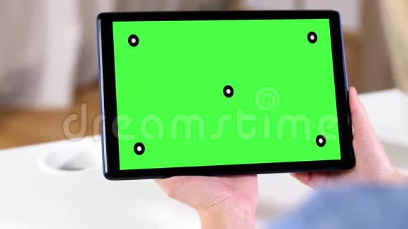 手拿平板电脑和绿色屏幕在家视频的预览图