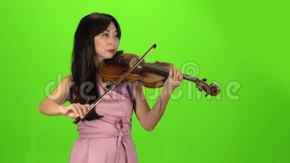 亚洲女孩拉小提琴绿色屏幕视频的预览图
