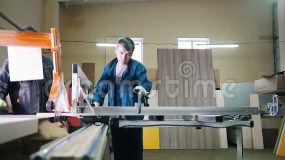 工人们正在家具厂用电锯切割木板视频的预览图