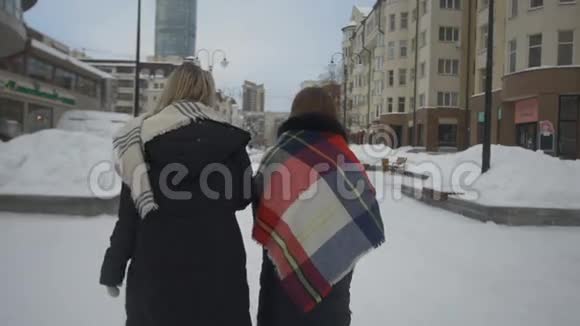 两个朋友在街上散步冬天喝咖啡视频的预览图