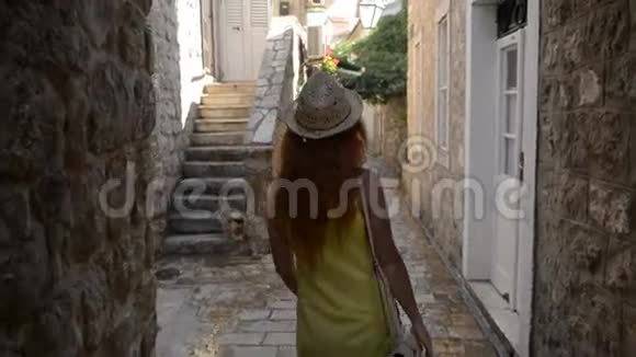 年轻女子漫步在一座古老的欧洲城市的街道上视频的预览图