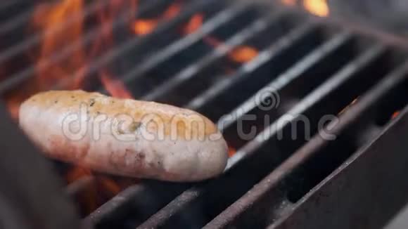 美味多汁的香肠烤火厨师在烤架上准备香肠扔在烤架上翻过来视频的预览图