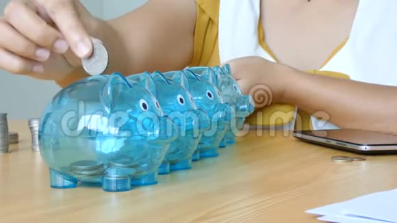 女人的手把钱币放在透明的存钱罐里用白纸做标记比喻花钱和储蓄视频的预览图