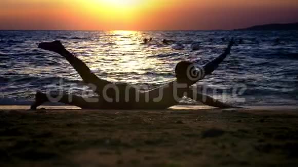 一个穿短裤的帅哥在海边做健身运动背景是美丽的日落视频的预览图