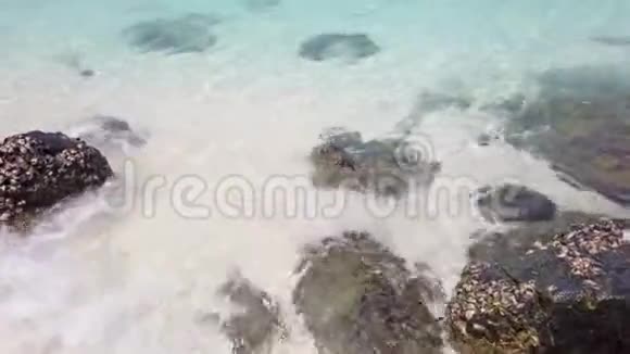 热带海洋景观沙滩上有岩石地平线上有岩石岛视频的预览图