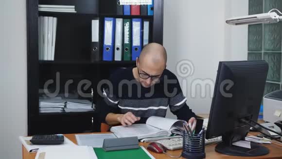 男性经理或办公室工作场所的调查员在电脑上工作视频的预览图