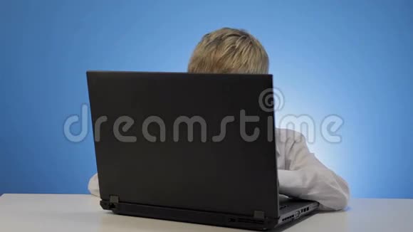 男孩在家里学习用笔记本电脑打字视频的预览图