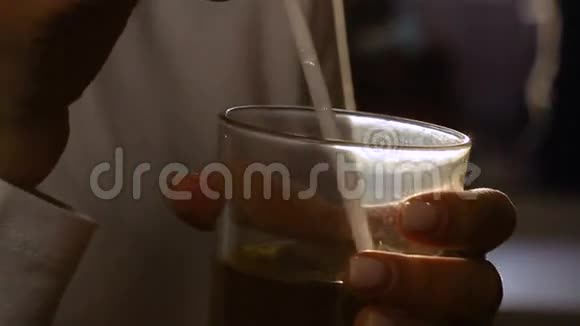 女人在日落时分喝着一杯带吸管的鸡尾酒微笑着高清镜头视频的预览图