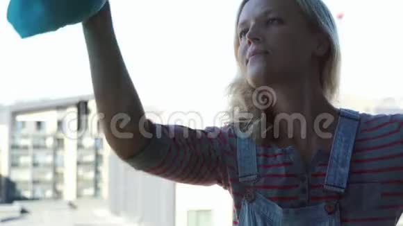 年轻的女人打扫窗户视频的预览图