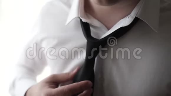 商人调整领带他的西装年轻的商人系好领带一个穿西装的男人的特写片段视频的预览图