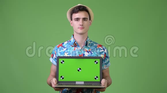 年轻英俊的游客展示笔记本电脑视频的预览图
