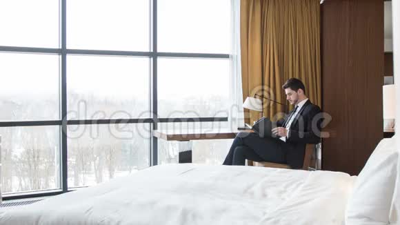 严肃的商人坐在他的旅馆房间里视频的预览图