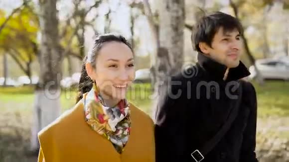 一对心情愉快的情侣在秋天的城市散步视频的预览图