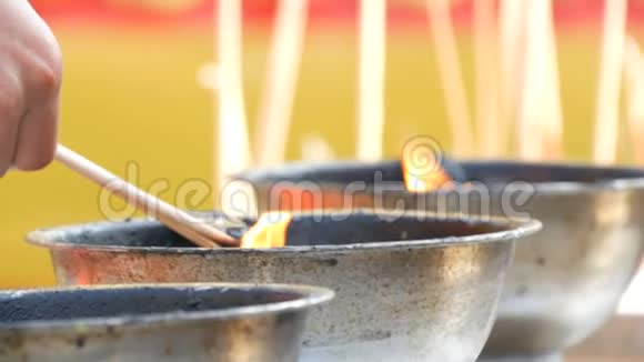 人们从一碗活火中点燃有香味的幸运魔杖和蜡烛佛教视频的预览图
