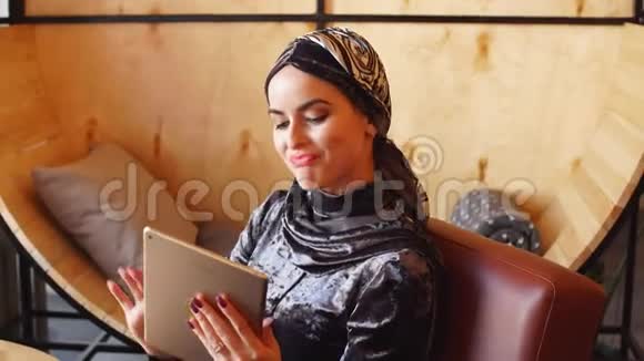 美丽的阿拉伯穆斯林女孩使用平板的肖像视频的预览图