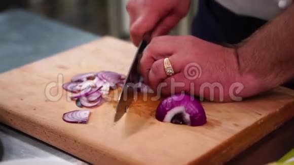 红葱头切球手放在棕色切割板上把洋葱切下来视频的预览图