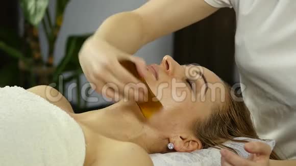 美容师在水疗沙龙为美女做面部按摩慢动作视频的预览图