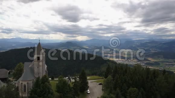 在山上的古教堂上空飞行奥地利卡林西亚马格达伦斯堡的真实景色美丽的山脉视频的预览图
