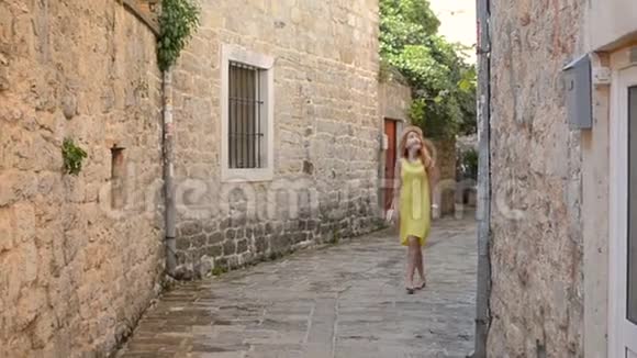 年轻女子漫步在一座古老的欧洲城市的街道上视频的预览图