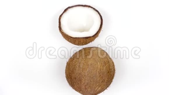 一整个椰子和一个半美味的果肉旋转在白色孤立的背景可循环无缝视频的预览图