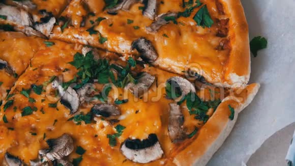 披萨刀用绿色鸡肉蘑菇和双奶酪切块披萨近距离观看视频的预览图
