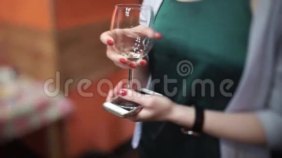 女人拿着杯子和电话站着美丽的女人手拿玻璃年轻女子双手特写肖像视频的预览图