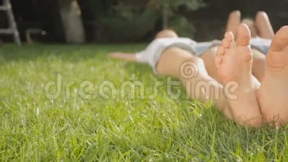 在公园的草地上躺着两个朋友的脚视频的预览图