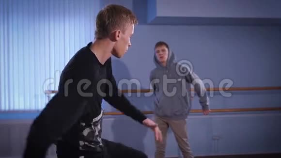 排练厅跳舞两个年轻的舞者穿着黑色夹克的年轻人做着下半身的动作视频的预览图